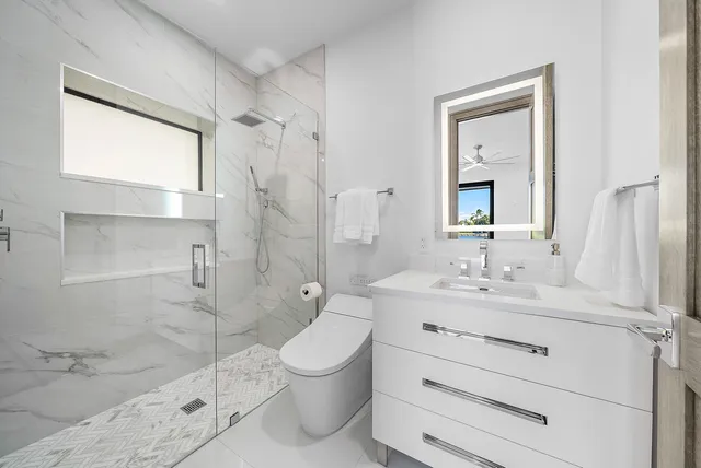 an empty room with windows and chandelier fan