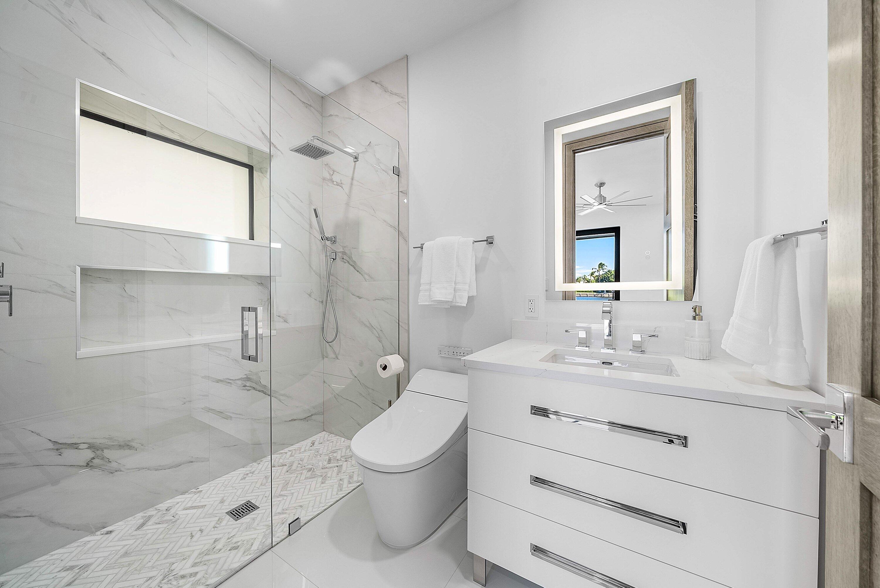 40 Spoonbill Road Manalapan, FL 33462 - Photo 37 of 67 a bathroom with a sink toilet a shower and a mirror