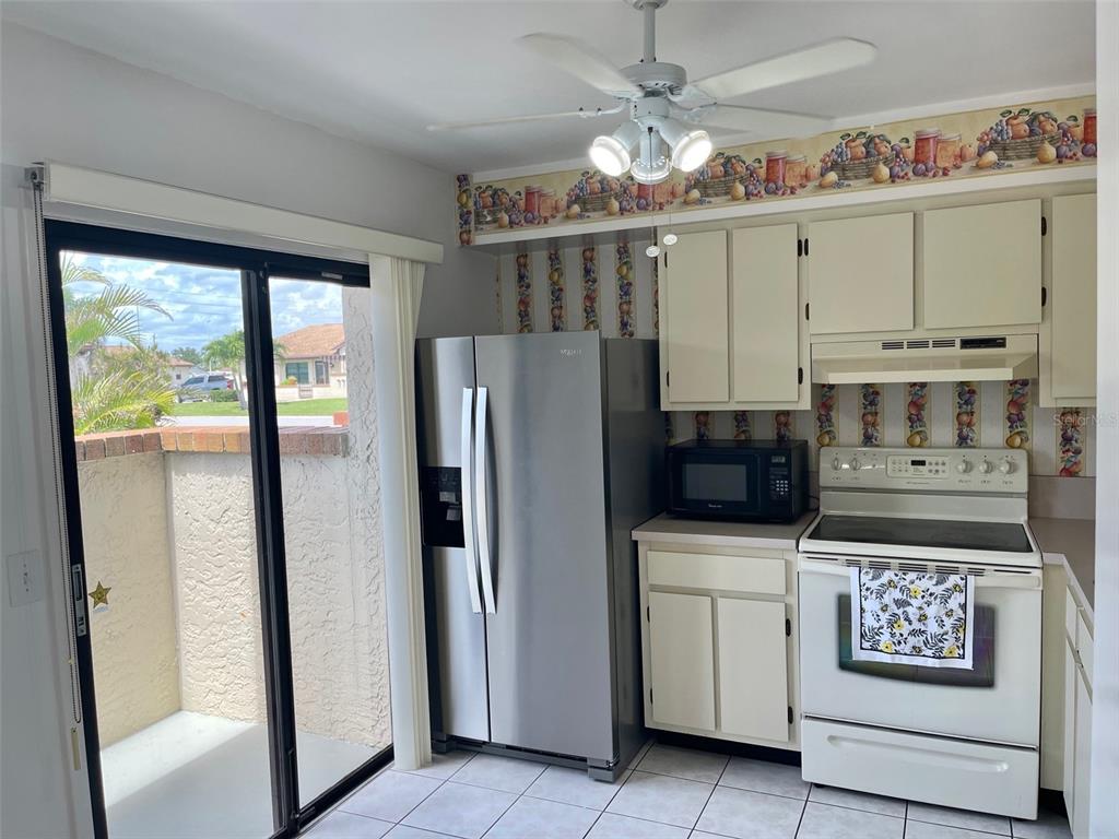 13100 South McCall Road, Unit 125 Port Charlotte, FL 33981 - Photo 5 of 19 a kitchen with stainless steel appliances a refrigerator sink and microwave