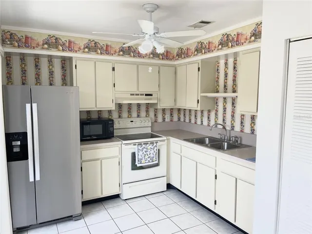a kitchen with stainless steel appliances a white cabinets and a chandelier