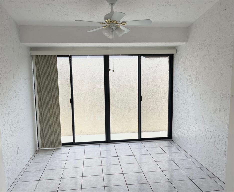 13100 South McCall Road, Unit 125 Port Charlotte, FL 33981 - Photo 7 of 19 a view of an empty room with window and chandelier fan