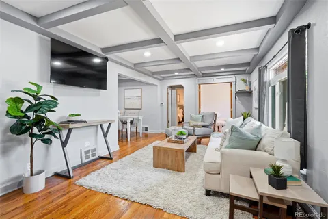 a living room with furniture floor to ceiling window and a flat screen tv