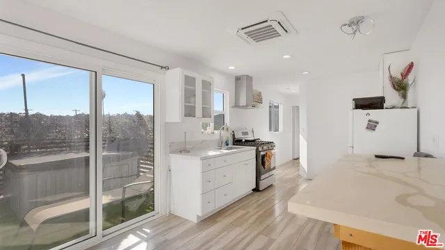 a kitchen that has a stove and a wooden floor