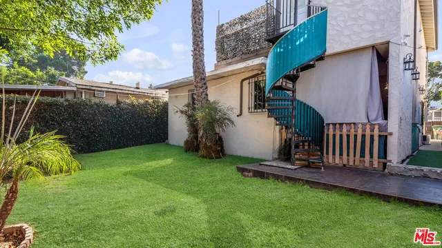 a view of backyard with deck and garden