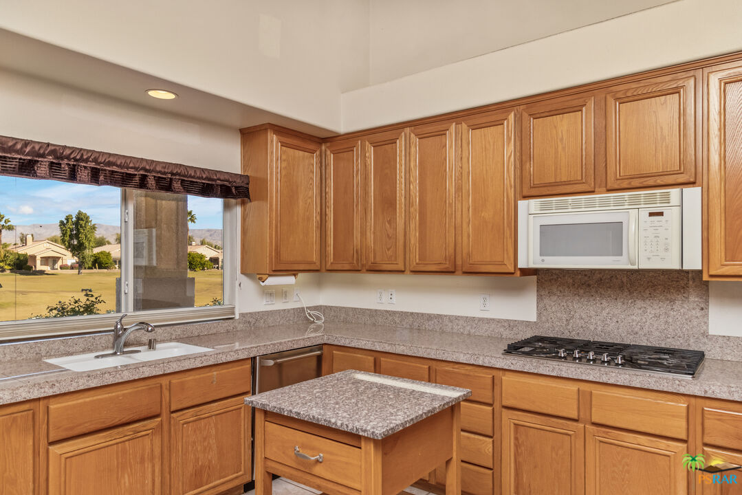 80372 Pebble Beach Drive Indio, CA 92201 - Photo 8 of 35 a kitchen with granite countertop a sink stove and cabinets