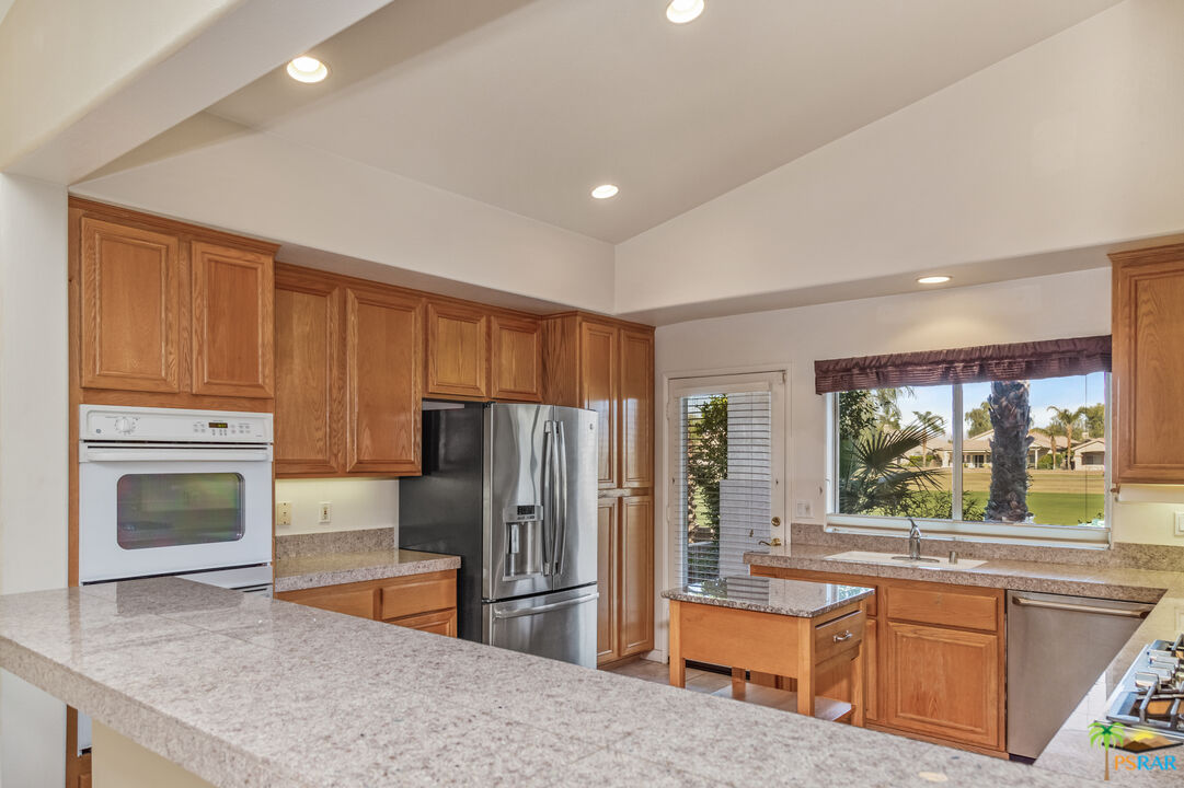 80372 Pebble Beach Drive Indio, CA 92201 - Photo 9 of 35 a kitchen with stainless steel appliances granite countertop a refrigerator a stove and a sink