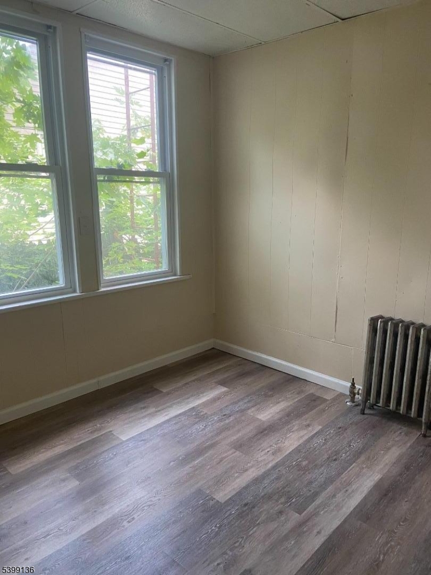 520 East 24th Street, Unit 1 Paterson, NJ 07514 - Photo 7 of 9 an empty room with wooden floor and windows