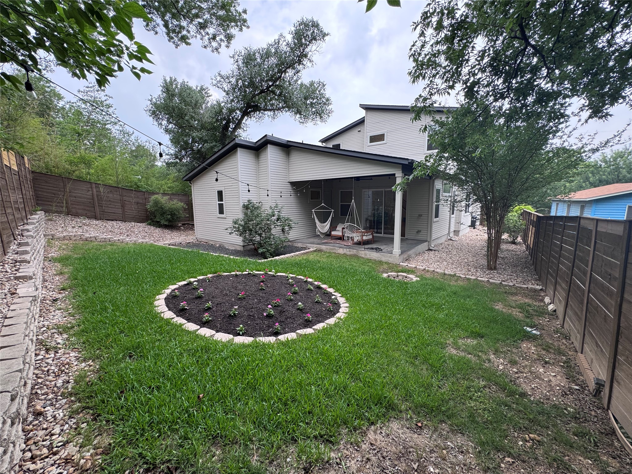 1719 Bunche Road Austin, TX 78721 - Photo 16 of 22 A well-maintained lawn and stone patio enhance this inviting home's outdoor living space.