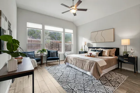 a bedroom with a bed and large windows