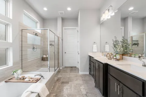 a bathroom with a double vanity sink mirror and shower