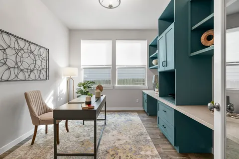 a view of a workspace with furniture and a window