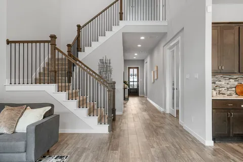 a view of a hallway with wooden floor and staircase