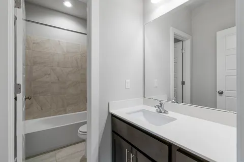 a bathroom with a sink shower and a mirror