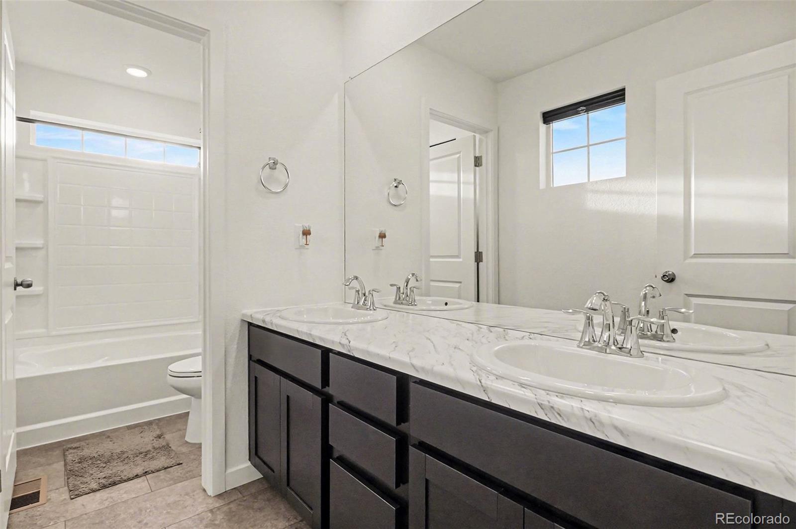 1053 Highpoint Trail Elizabeth, CO 80107 - Photo 15 of 28 a bathroom with a granite countertop sink a toilet and shower