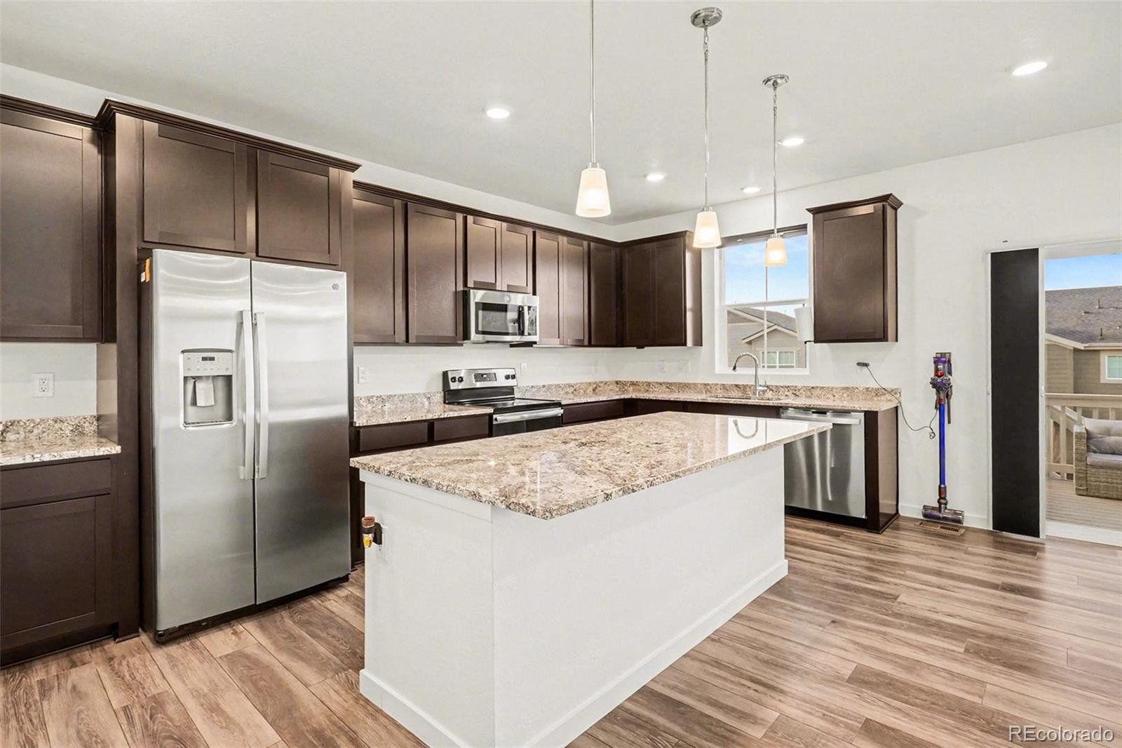 1053 Highpoint Trail Elizabeth, CO 80107 - Photo 7 of 28 a large kitchen with stainless steel appliances granite countertop a refrigerator a stove a sink and a oven