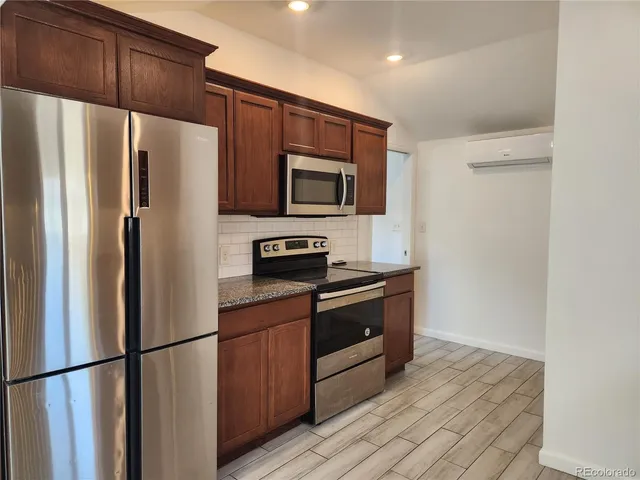 a kitchen with stainless steel appliances granite countertop a refrigerator stove and microwave