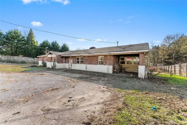 a view of a house with backyard and trees