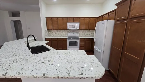 a view of a kitchen with a sink and chandelier