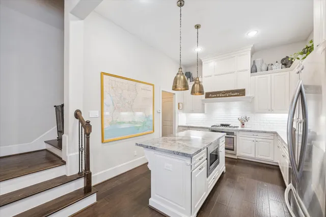 a kitchen with stainless steel appliances granite countertop a sink a stove and a refrigerator