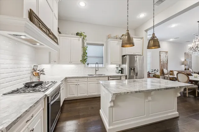 a kitchen with kitchen island granite countertop a sink stove and cabinets