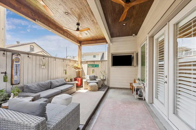 a living room with furniture a flat screen tv and a floor to ceiling window