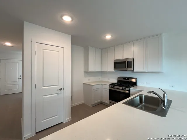 a kitchen with a refrigerator a sink a stove a microwave and cabinets