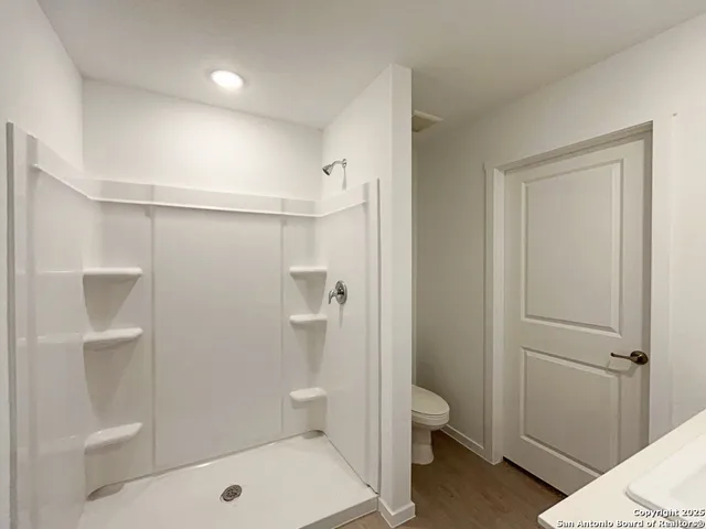 a bathroom with a toilet and a shower