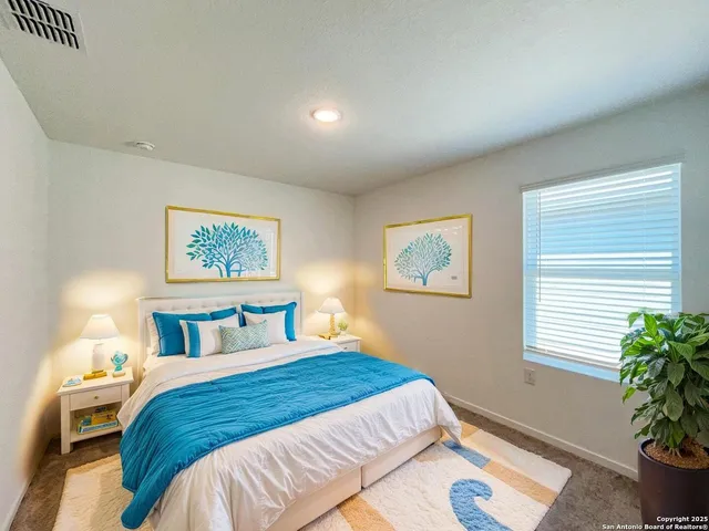 a bedroom with a large bed and a potted plant