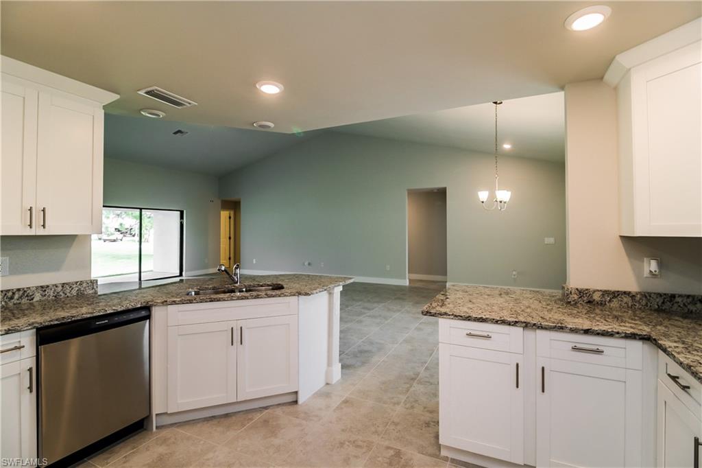 1004 Anson Avenue Lehigh Acres, FL 33971 - Photo 3 of 15 a kitchen with granite countertop a sink and cabinets