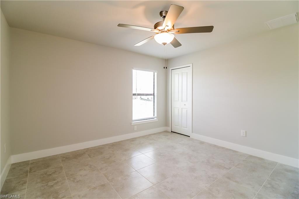 1004 Anson Avenue Lehigh Acres, FL 33971 - Photo 7 of 15 an empty room with windows and ceiling fan