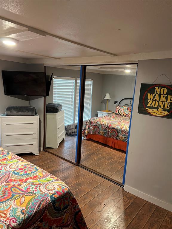 2334 San Bar Road, Unit 54 Graford, TX 76449 - Photo 10 of 28 a bedroom with a bed and a flat tv screen on dresser