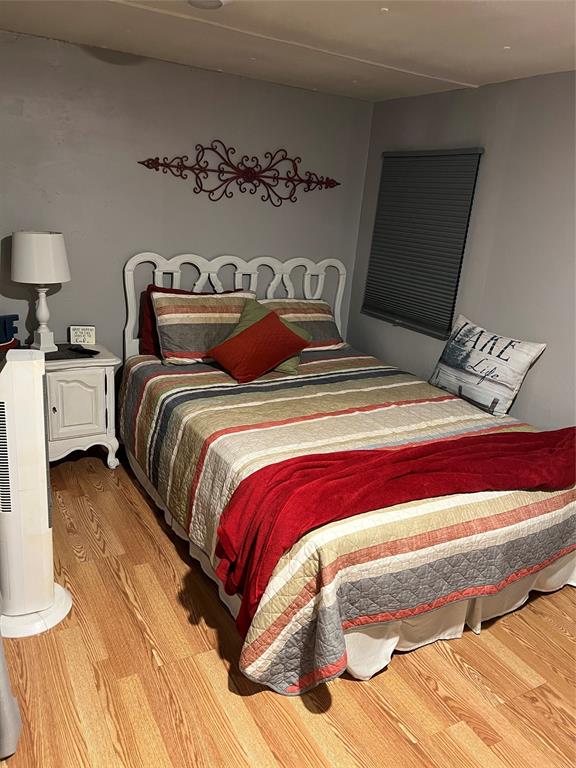 2334 San Bar Road, Unit 54 Graford, TX 76449 - Photo 14 of 28 a bedroom with a bed and wooden floor