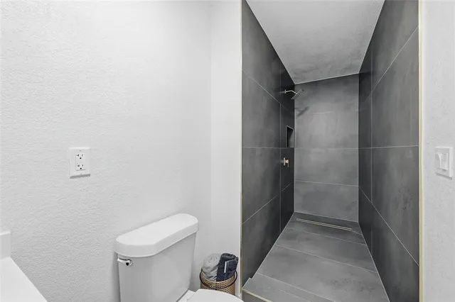 a bathroom with a toilet and a shower