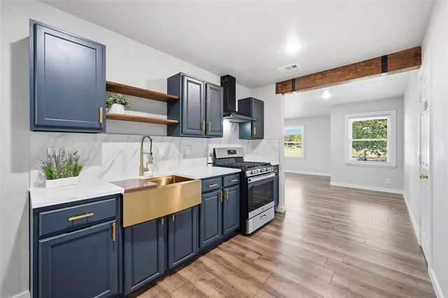 a kitchen with stainless steel appliances granite countertop a sink stove and refrigerator