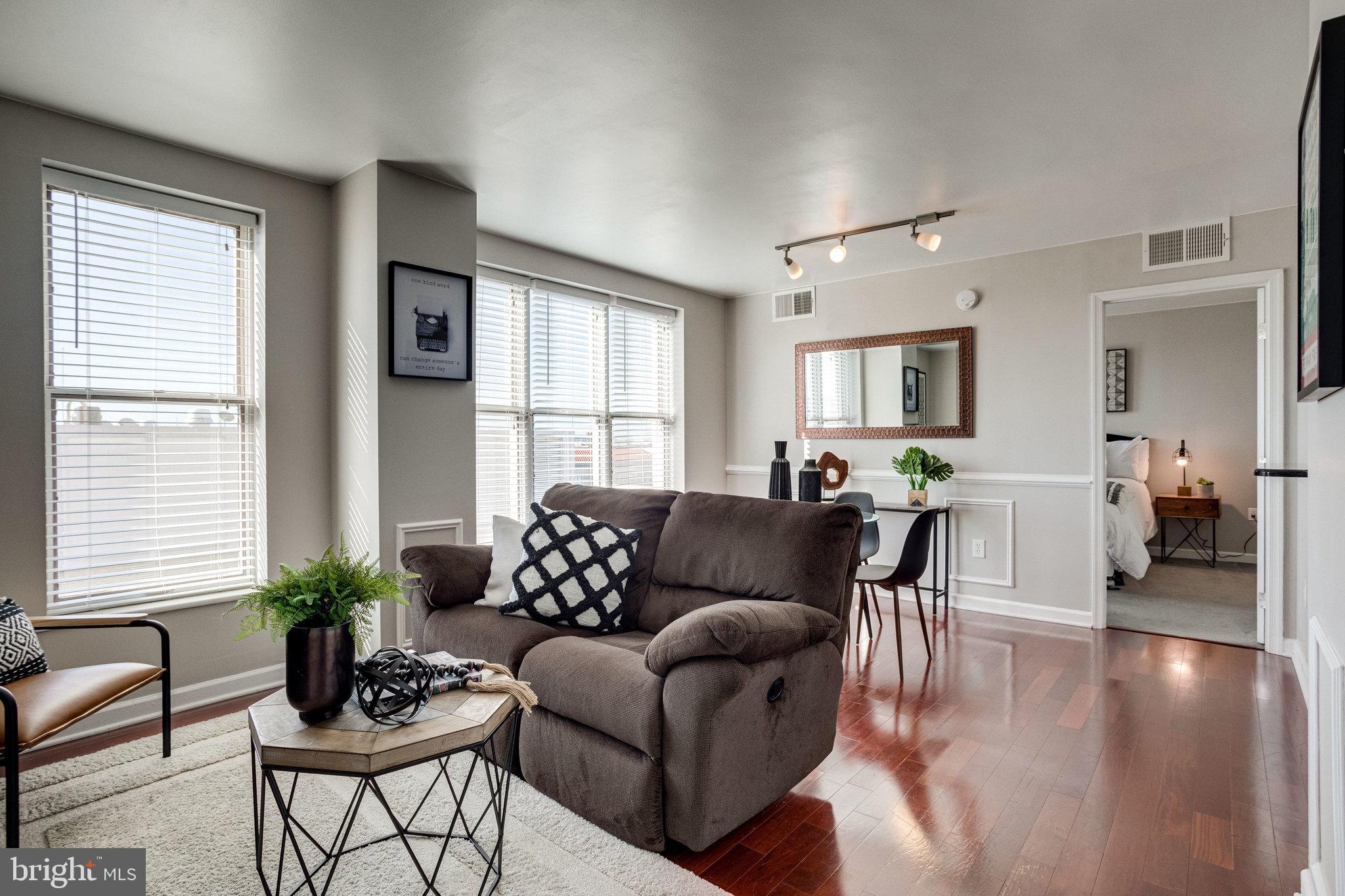 a living room with furniture and a wooden floor