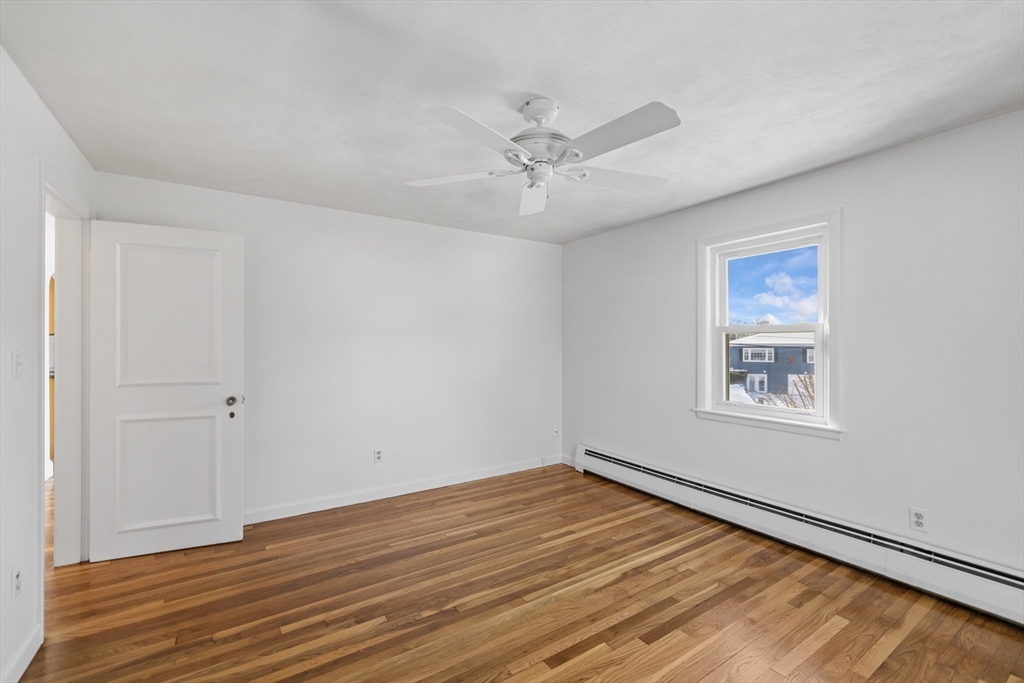 30 Haley Road, Unit 1 Marblehead, MA 01945 - Photo 9 of 21 an empty room with wooden floor ceiling fan and windows
