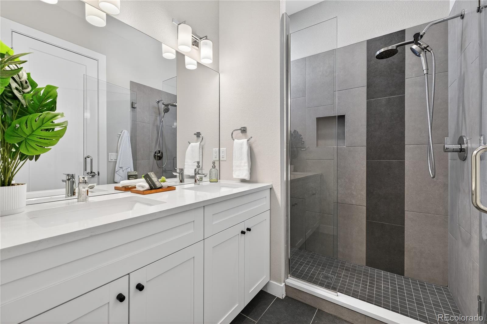 925 Inca Street, Unit 7 Denver, CO 80204 - Photo 27 of 42 a bathroom with a double vanity sink mirror and shower