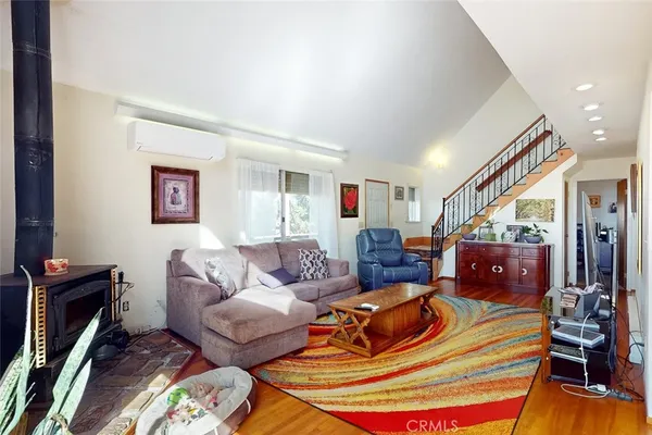 a living room with furniture stairs and a large window