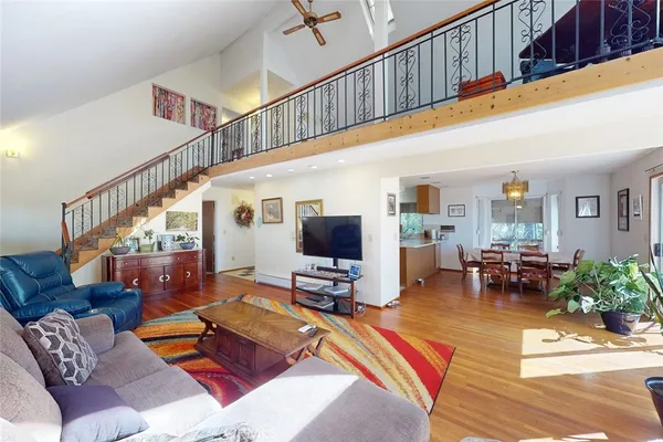 a living room with furniture a wooden floor and a ceiling fan