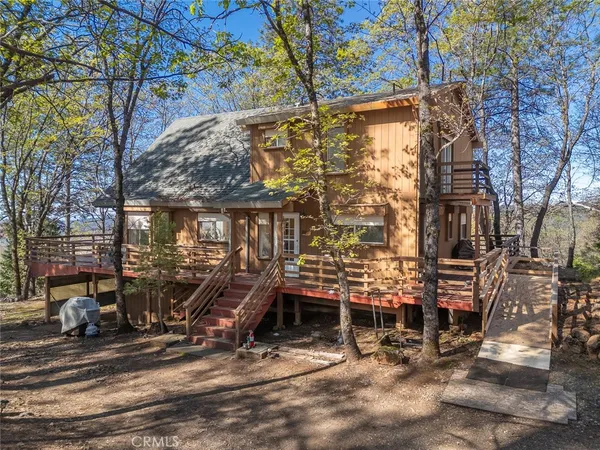 a view of a house with a tree and car parked