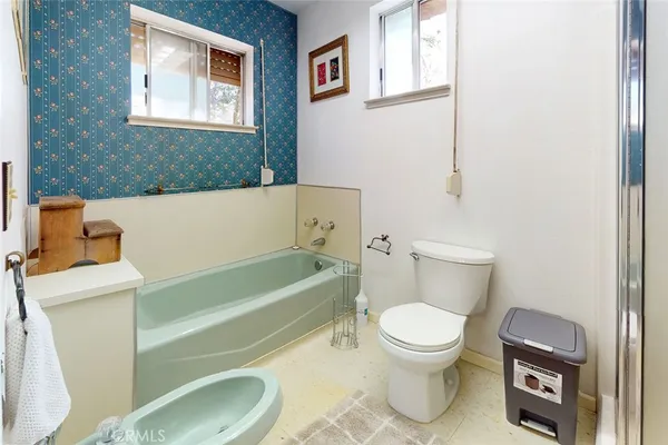 a white toilet sitting next to a bathroom sink and vanity