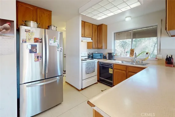 a kitchen with stainless steel appliances a sink stove and wooden cabinets
