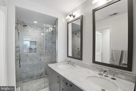 a bathroom with a sink shower and a mirror