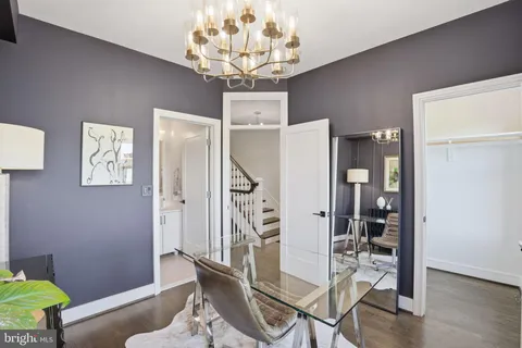 a dining room with wooden floor and chandelier