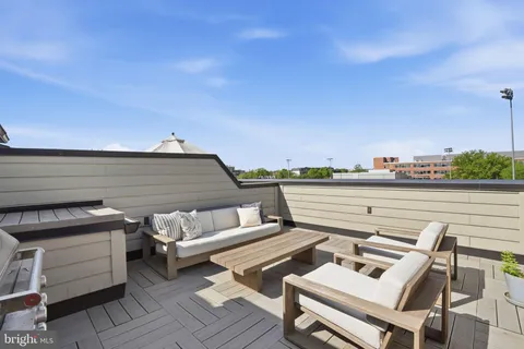 a roof deck with couch and chairs