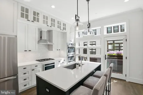 a kitchen with stainless steel appliances a stove a table and chairs