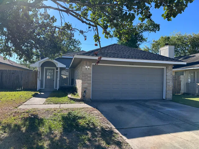a view of a house with a small yard plants and large tree