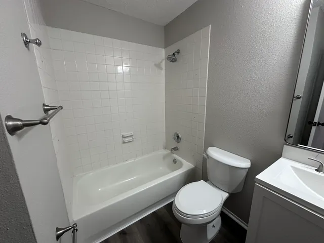 a white toilet sitting next to a bath tub