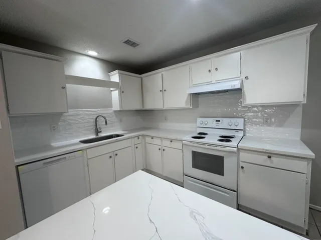 a kitchen with cabinets appliances and a sink