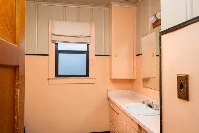 a bathroom with a granite countertop sink a mirror and a shower
